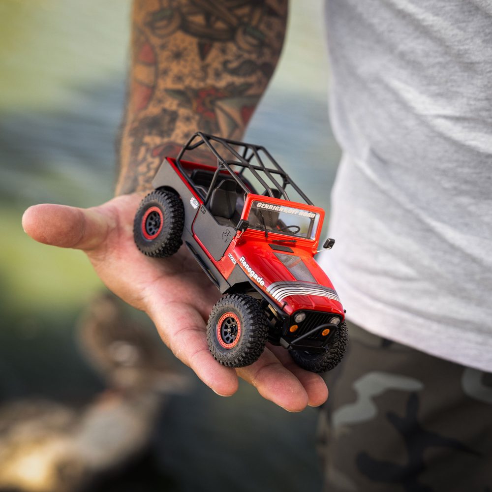 Axial SCX30 Jeep CJ-7 in Red (GenRight) held in one hand, showing its 1/30 palm size